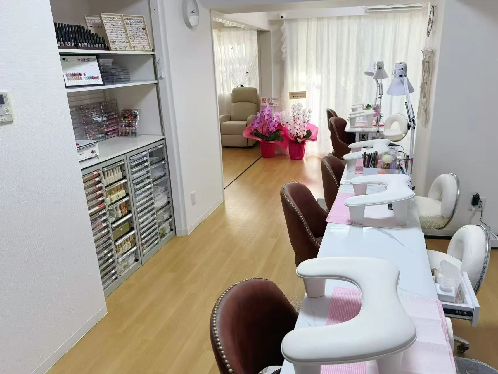 カラージェルの棚と白い施術テーブルが並ぶ＆MEネイルサロン蒲田西口店の店内